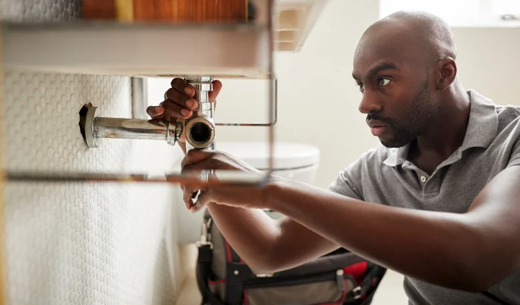 a male plumber fixing a pipe connection from Real and Actual in Leander, TX - Plumber near me